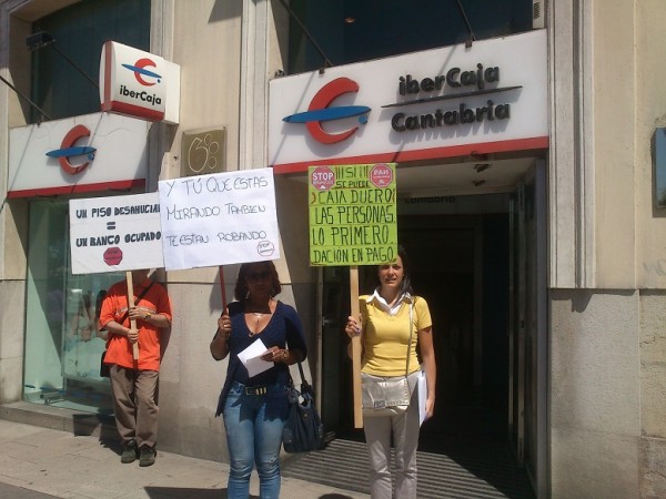 Miembros de la PAH de Cantabria en la puerta de la oficina de Ibercaja que ha sido ocupada por la plataforma