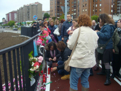 Vecinos colocando un altar con flores, velas y poemas recordando a Amparo.