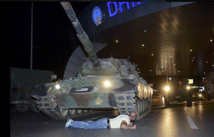 Un hombre se tumba frente a un tanque. Foto: Reuters.